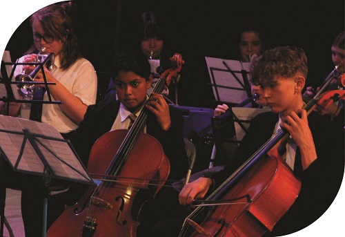 An image of two students playing cellos