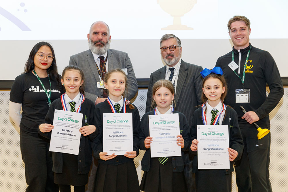 The winning team from Woodlands, with judges Danica Fronda, Gordon Farqhuar, Sam Crick, and CET Chief Executive Marc Jordan. A group of young pupils stand hold certificates and wearing medals